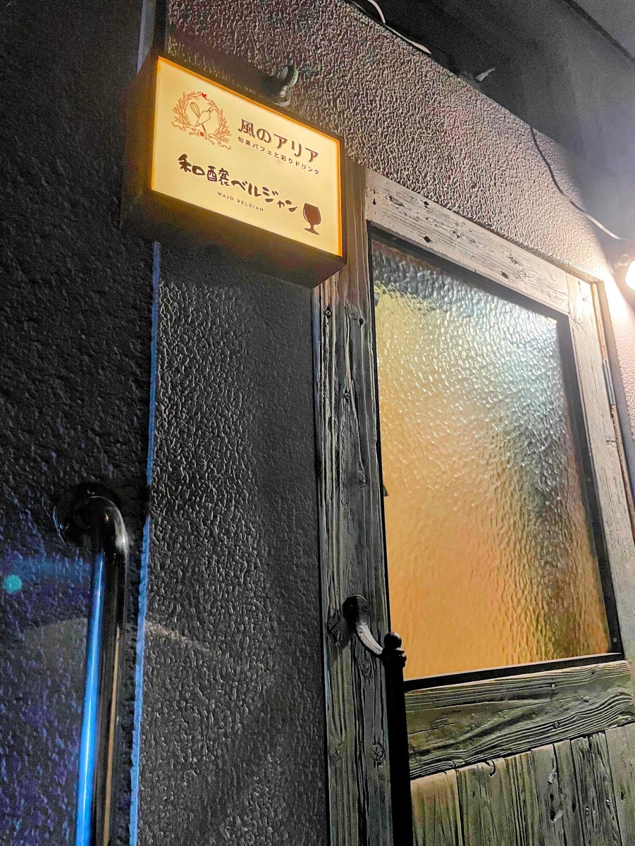 あけぼのビル2階の入口。木の扉の上に和醸ベルジャンの看板